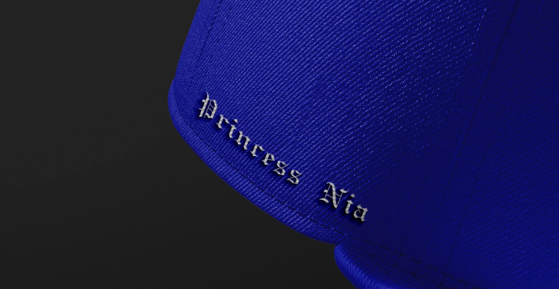 Side view of the Princess Nia Snapback, showcasing the embroidered text 'Princess Nia' in elegant black lettering on the royal blue fabric.